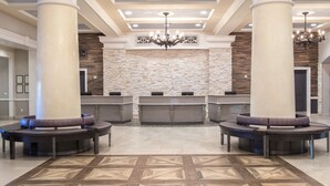 A lobby with a reception desk, two large columns, a chandelier, and a patterned floor. - 2 Bed 2 Bath Las Vegas - Pools, Hot Tubs, Cabanas and More! (Las Vegas)