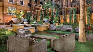 An indoor courtyard with artificial grass, wicker furniture, and large planters. - 2 Bed 2 Bath Las Vegas - Pools, Hot Tubs, Cabanas and More! (Las Vegas)