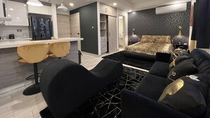 Un appartamento moderno con cucina, zona pranzo e camera da letto con copripiumino leopardato.