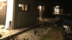 Un bâtiment moderne avec une entrée illuminée et une voiture garée à proximité.