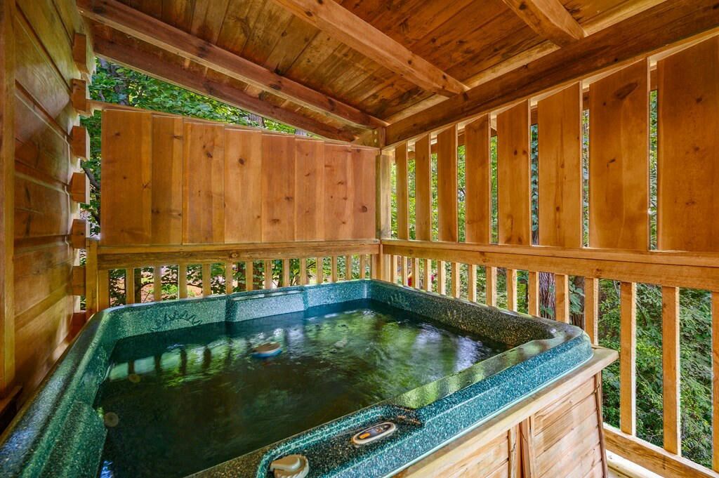 A wooden spa area with a hot tub and wooden railings.