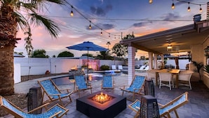 Eine Terrasse im Freien mit Lounge-Möbeln, einem Feuerkorb und Lichterketten.