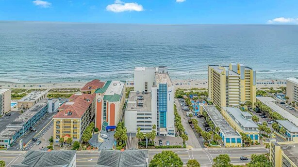 A coastal cityscape with a marina, modern buildings, and a clear view of the ocean. - 4-min Walk to Ocean|2 King Suites|Beach Retreat (Myrtle Beach)