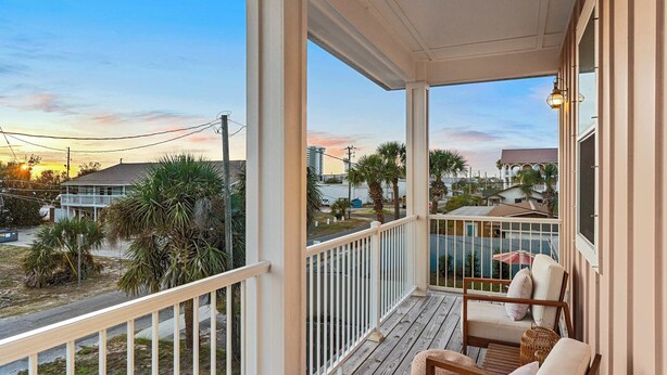 A covered porch with a view of the street and neighboring buildings. - 6-Min Walk to Beach | Heated Pool | Fenced Yard (Panama City)