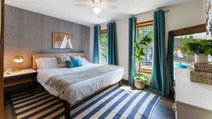 A bedroom with a bed, bedside table, lamp, curtains, and a ceiling fan. - 5BR|Private Lake|Pools|Hot Tub|Near Camelback (East Stroudsburg)