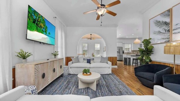 A modern living room with a large flat-screen TV, a ceiling fan, and a cozy seating area with a sofa and armchairs. - Private Pool | Near MarshWalk & Beach | Fire Pit (Murrells Inlet)