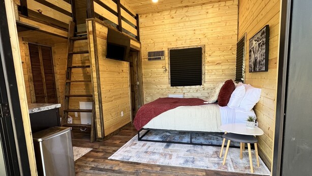 A compact bedroom with a bunk bed, a small bedside table, and a single bed with pillows. - "The Matador" Westcliffe Outpost Cabin  (Westcliffe)
