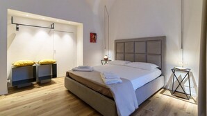 Un dormitorio moderno con una cama grande, un armario y una mesita de noche.