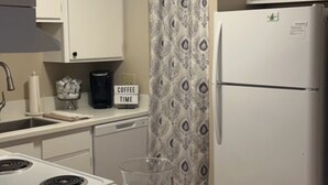A kitchen with white cabinets, a refrigerator, a coffee maker, and a sign that says "Coffee Time". - Cozy condo in Waterville Valley NH.  (Waterville Valley)
