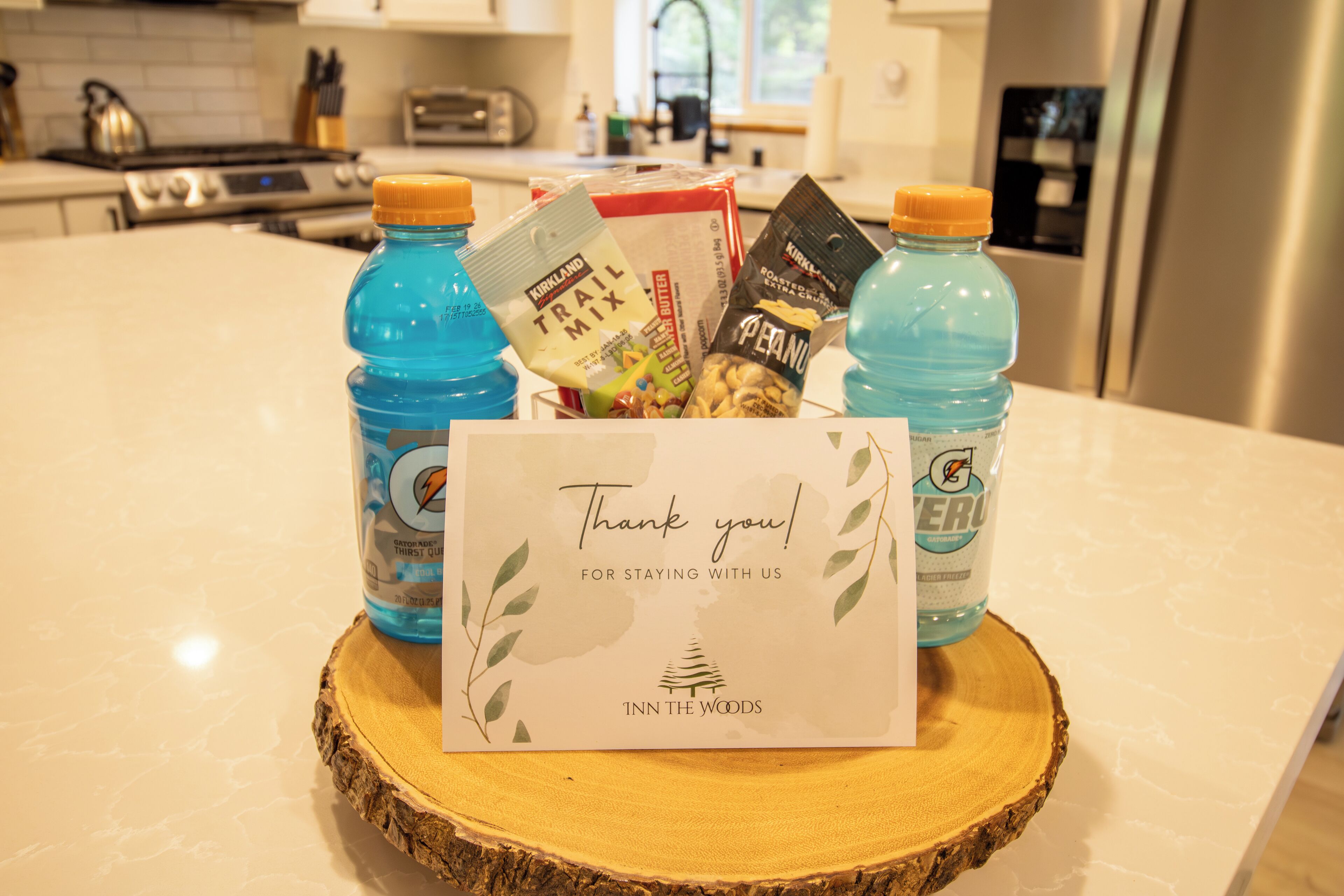A kitchen counter with a thank you card, two bottles of water, and snacks.