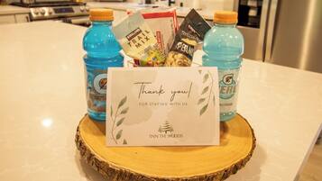 A kitchen counter with a thank you card, two bottles of water, and snacks.
