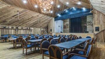 A rustic wooden hall with tiered seating and a stage.