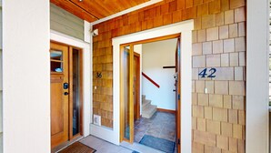 A wooden exterior with a number 36 door and a number 42 door leading to a staircase. - Settler's Crossing #42 (Sun Peaks)
