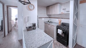 Uma cozinha moderna com bancadas de granito, forno embutido e armários de madeira.