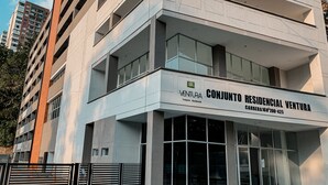 Um edifício residencial moderno com uma placa de destaque para 'CONJUNTO RESIDENCIAL VENTURA'.