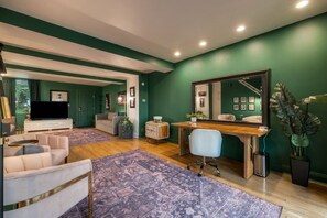 Una sala de estar moderna con un sofá, una mesa de centro, un televisor y un escritorio con una silla.