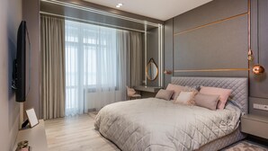 Une chambre moderne avec un grand lit, un bureau et une télévision.