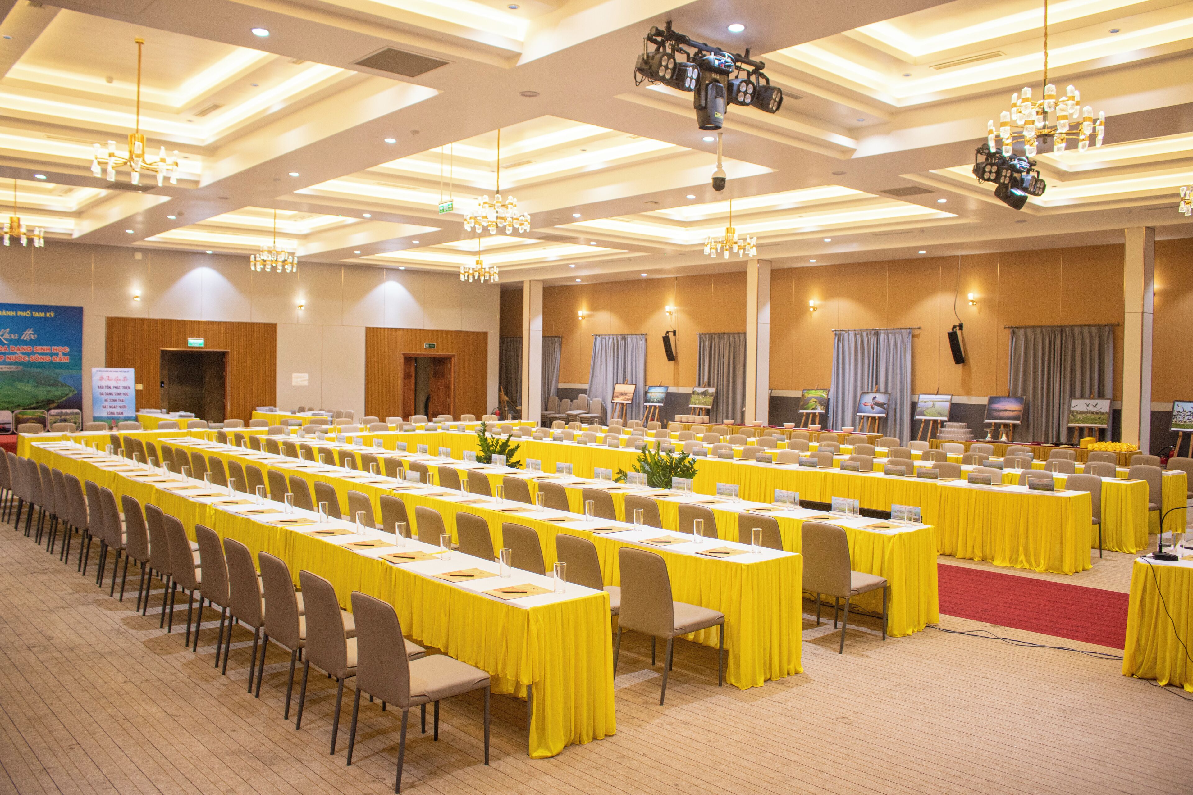 Un'ampia sala conferenze con file di tavoli e sedie, dotata di cartellini e microfoni.