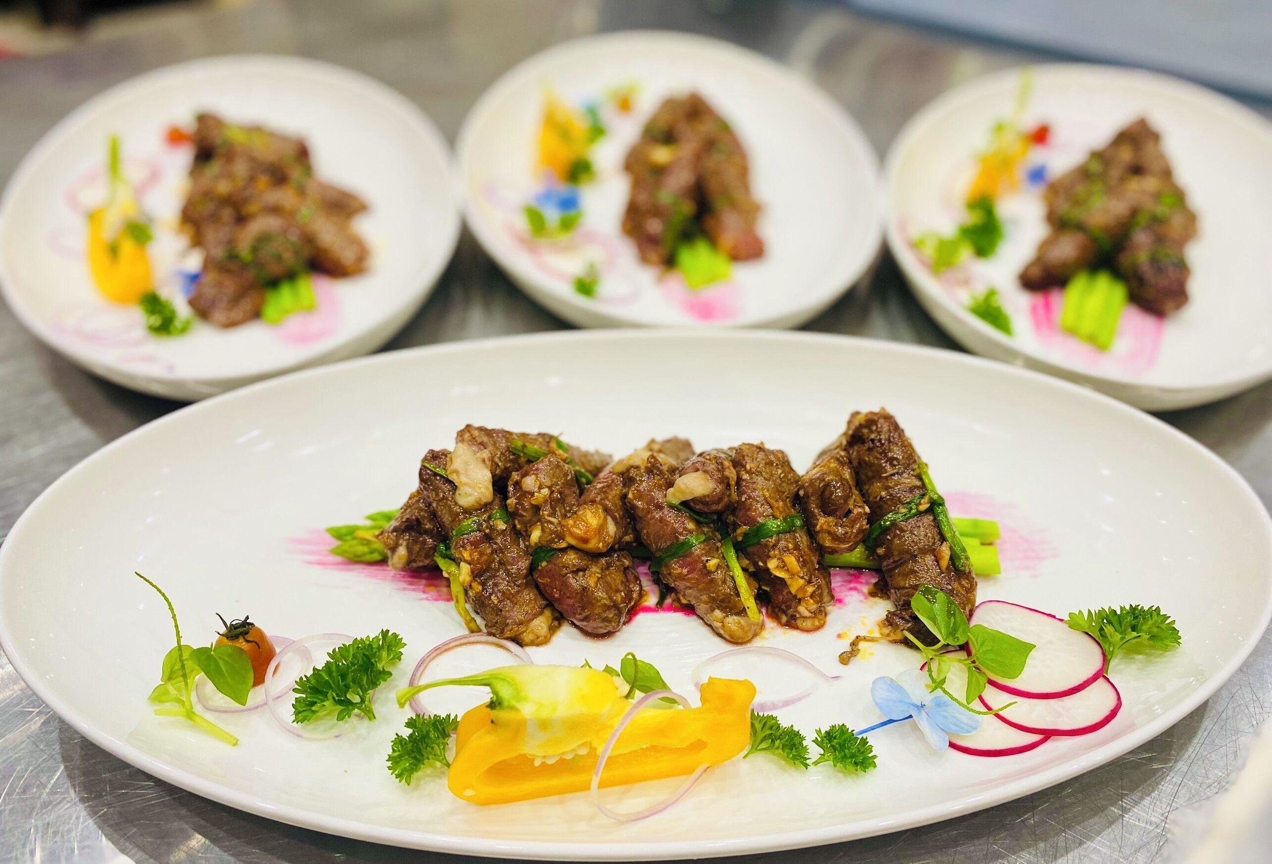 Een bord eten met diverse garneringen en een paar borden op de achtergrond.