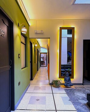A hallway with a statue, a door labeled '102', and a window with a view. - HOSTAL PURA VIDA LA 70 (Medellín)