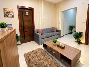 Una sala de estar moderna con un sofá gris, un mueble de madera y una mesa de centro.
