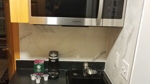 A compact kitchen with a stainless steel microwave, a coffee maker, and a small refrigerator. - Comfortable cabin in the mountains of North Carolina, located near TIEC. (Mill Spring)