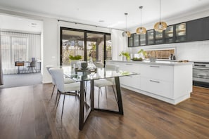 Enjoy meals and relaxation in this well-lit kitchen with a central island, dining table, and cozy seating area.