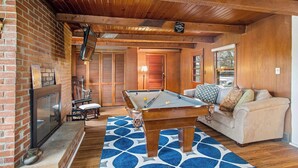 A cozy room with a pool table, a sofa, and a fireplace. - Escape To The Countryside At Black Oak Farm (Mount Carroll)