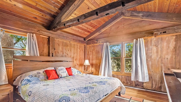 A wooden cabin bedroom with a bed, curtains, and a window. - Escape To The Countryside At Black Oak Farm (Mount Carroll)