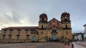 Ein historisches Gebäude mit einem zentralen Eingang, zwei Glockentürmen und einem Innenhof.