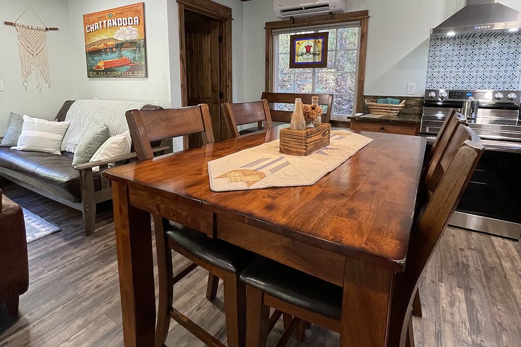 Un espace repas comprenant une table en bois, des chaises et un élément décoratif central.