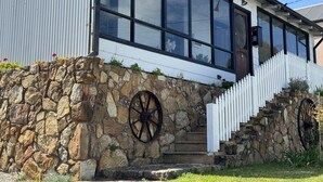 A modern house with a stone foundation, large windows, and a white picket fence. - Enjoy our Wee Gem, she is over 120 years young and has been loving restored. (Albany)
