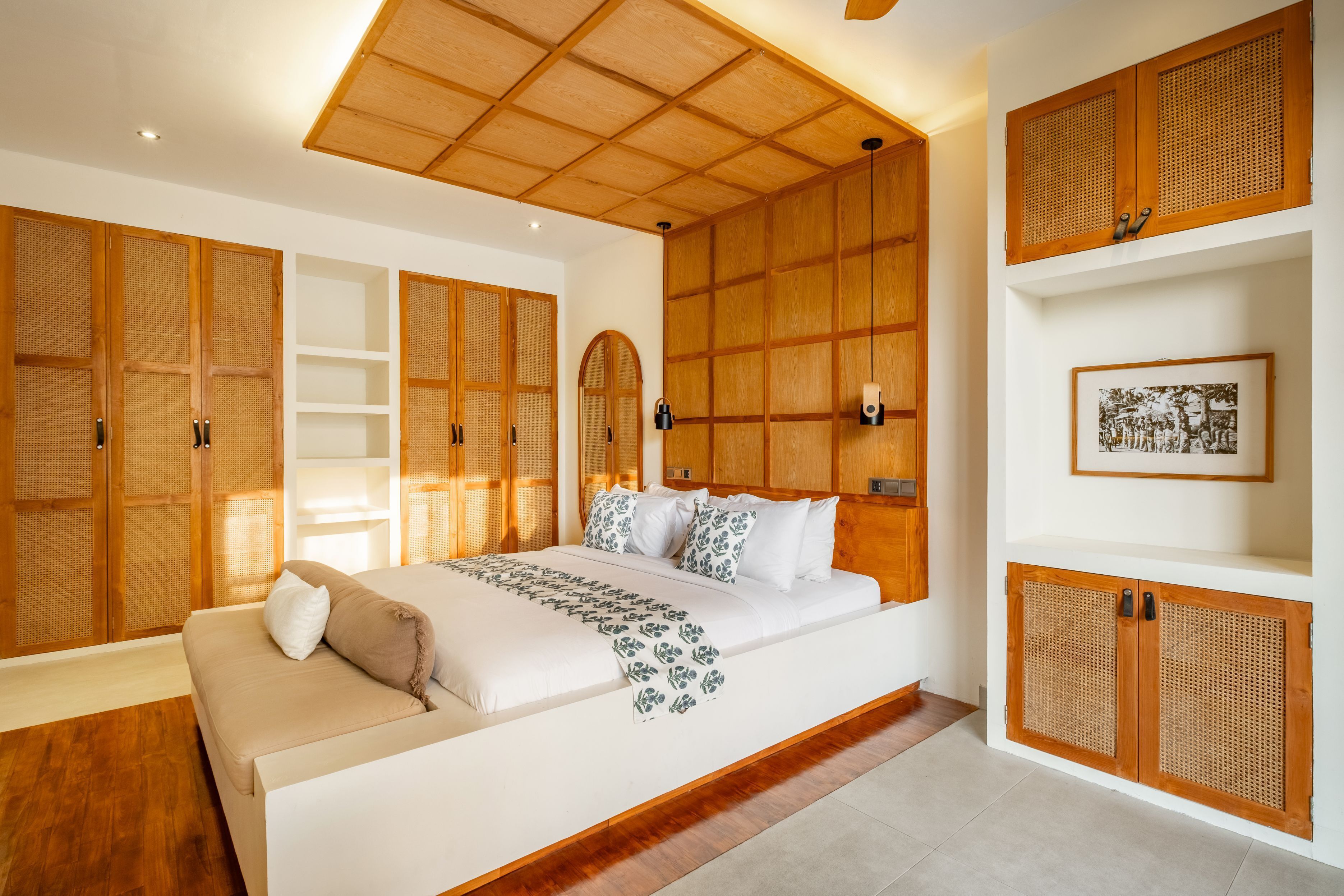 Une chambre spacieuse avec un grand lit, des lambris en bois et un ventilateur de plafond.