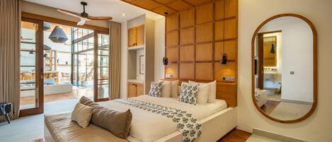 A modern bedroom with a large bed, wooden ceiling, and a view of the outdoor seating area.