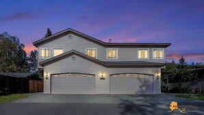 A two-story house with a garage, a visible address sign, and a clear sky. - Centrally located in UMed District. Steps from AK Air Venue, Prov/ANMC Hospitals (Anchorage)