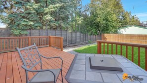 A wooden deck with a metal bench and a grill area. - Centrally located in UMed District. Steps from AK Air Venue, Prov/ANMC Hospitals (Anchorage)