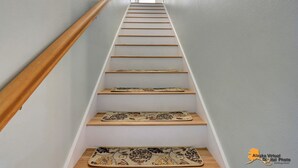 A staircase with wooden handrails and a light-colored wall. - Centrally located in UMed District. Steps from AK Air Venue, Prov/ANMC Hospitals (Anchorage)