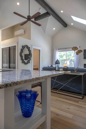 Et moderne køkken med en granitbordplade, en loftsvifte og en blå vase på en hylde.