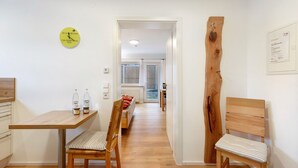 Ein Flur mit einem Holztisch, Stühlen, einer Uhr und einem Zertifikat an der Wand.