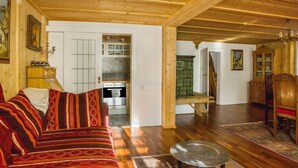 Ein gemütliches Wohnzimmer mit Sofa, Esstisch und einer Küche im Hintergrund.