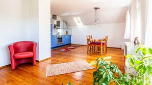 A modern apartment with a kitchen, dining area, and a red chair. - Apartment 'Elstar' with Wi-Fi (Stockach)