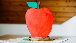 Una manzana de madera como adorno sobre una mesa.