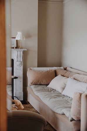 Un dormitorio con cama, lámpara y chimenea.
