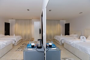 Une chambre d’hôtel avec deux lits, une machine à café et un mini-bar.