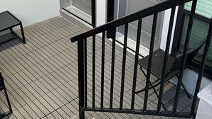 Una terraza de madera con barandilla de metal que conduce a un conjunto de puertas dobles, cada una con el número 2771.