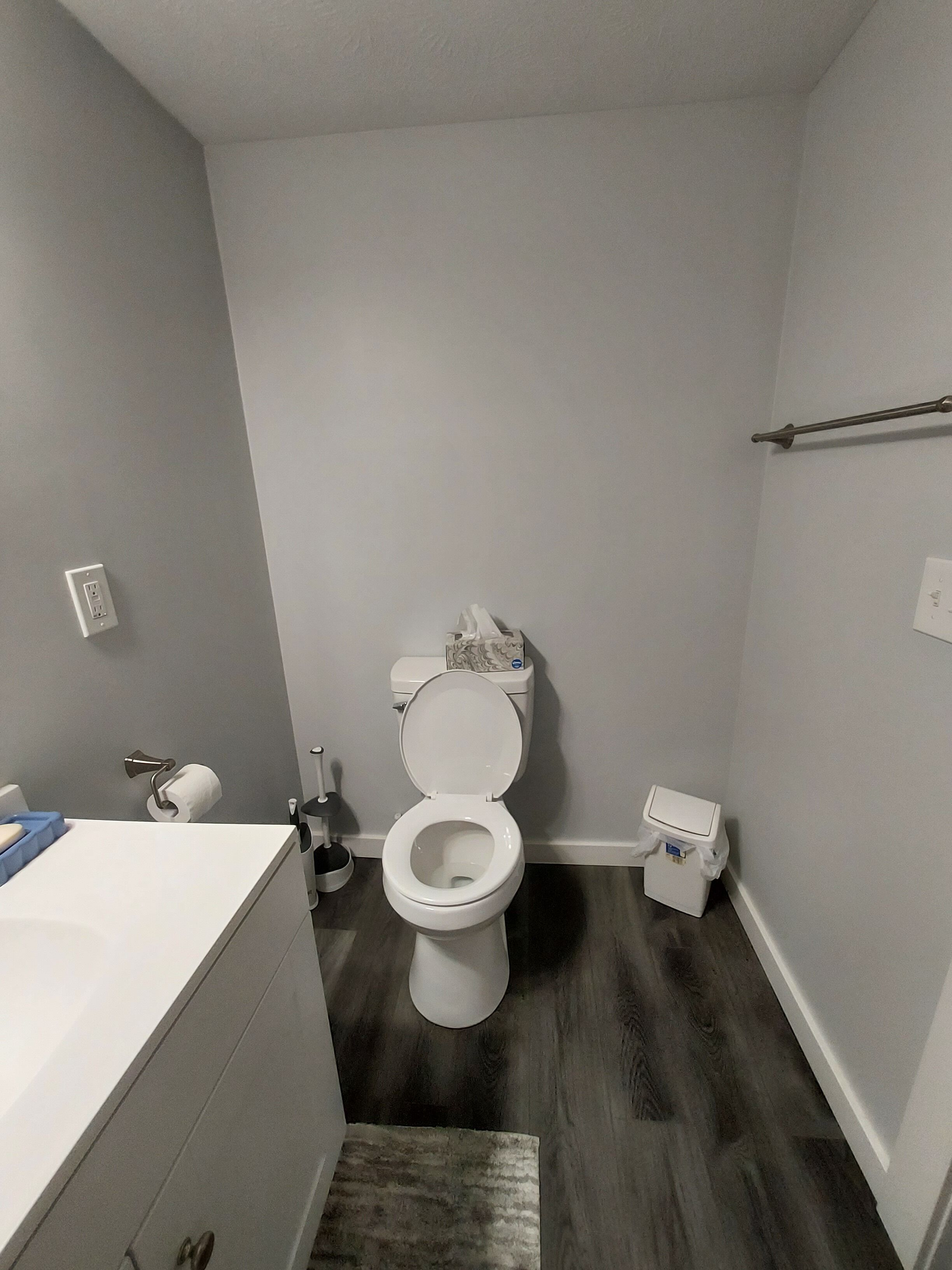 Une petite salle de bain moderne équipée de toilettes, d’un lavabo et d’une poubelle.
