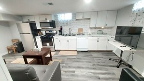 En kompakt bolig med tekøkken, spiseplads og opholdsområde.