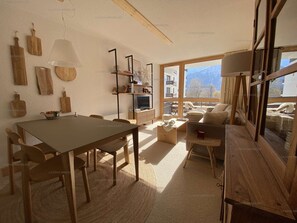 Um interior aconchegante com uma mesa de jantar de madeira, um sofá e uma televisão.