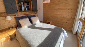 Un dormitorio con cama, mesita de noche, lámpara y ventana con persianas.