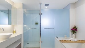A modern bathroom with a glass-enclosed shower, a white sink, and a vanity with a mirror. - Elysia Wellness Retreat (Pokolbin)